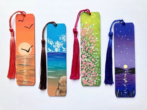 Set of 4 hand painted wooden bookmarks with tussle. Price is for 4 bookmarks. one from each design. Size:  Length: 12cm Width: 3cm Depth: 2mm  Painted in acrylic.  Mini original landscape paintings. 4 options available. Back of the bookmark is painted in plain colour. Colourful tussle is attached. Tussle colour may vary. Personalised name or a short phrase can be added on the reverse of the bookmark.(optional) You can have one name for all 4 bookmarks or 4 different names. Please enter a name/names/ phrase in the personalisation box.(Optional) Lovely gift for a reader. Not a toy for Children. Thank you for visiting Nuwajayarts. Please check out my other original artwork here. https://www.etsy.com/uk/shop/NuwaJayArts Painted Wooden Bookmarks, Painted Bookmarks, Wooden Bookmarks, Creative Bookmarks, Personalized Bookmarks, Unique Bookmark, Assistant Gifts, Plain Colour, Book Marks