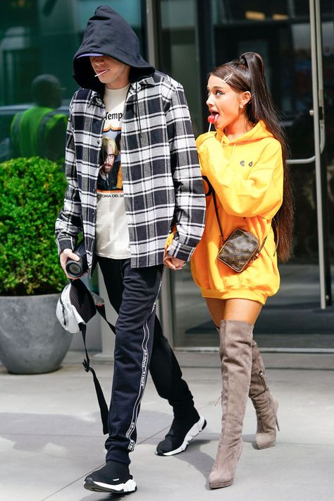 Halloween Couples Costumes Pete Davidson and Ariana Grande Pete and Ariana are all about unseasonable dressing. These outfits, for example, were worn in the dead of summer. The recipe for Pete: graphic tees, track pants, and hoodies. For Ari, an oversized hoodie, over-the-knee boots, and a high pony. (Her look is called lampshading. More on that here.)  ##halloween Ariana Grande Cover, Ariana Grande Tattoo, Pete Davidson, Walking Down The Street, Ariana Grande Outfits, Ariana Grande Style, Yellow Hoodie, Hailey Baldwin, Hoodie Outfit