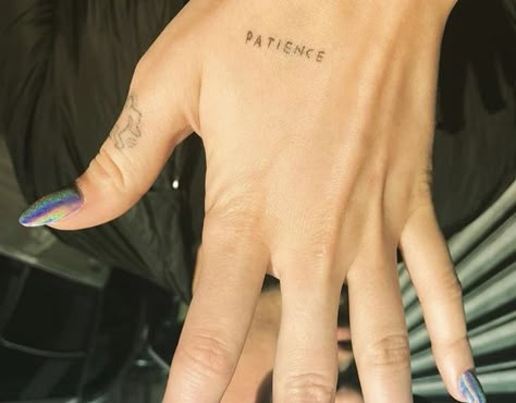 Tattoo: PATIENCE inked on her left hand. Meaning: Dua Lipa revealed through Instagram the “PATIENCE” tattoo on her left hand in April 2017. In an interview, she explained that the tattoo is a constant reminder for her to stay calm and be patient. Dua Lipa Tattoo, Patience Tattoo, 13 Tattoos, Single Needle Tattoo, Hand Tattoos For Women, Dad Tattoos, Red Tattoos, Poke Tattoo, Dainty Tattoos