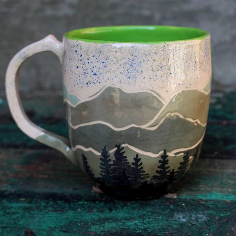 This mag is made by pottery wheel, then hand illustrated, this mountain made in graffiti technique, and forest and sky hand painted. More in our shop https://www.etsy.com/shop/LebidCeramics Mountain Bowl Pottery, Pottery Mug Mountains, Ceramic Mug Mountains, Hand Painted Mugs For Men, Tree Pottery Painting, Mug Painting Ideas Mountains, Pottery Painting Ideas Mountains, Mountain Pottery Painting Ideas, Pottery Painting Mountains