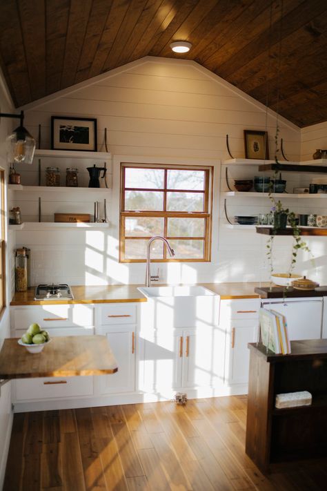 The kitchen has open shelving, custom steel brackets, a farmhouse sink, and butcher block countertops. Tiny Farmhouse, Small Tiny House, Tiny House Builders, Wind River, Best Tiny House, Farmhouse Kitchen Cabinets, Tiny House Kitchen, Minimalist Life, Tiny House Movement