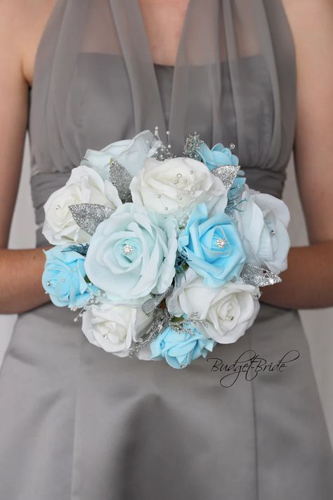 This lovely assortment of blue and white flowers is bound to turn heads on your wedding day. Composed of stunning roses in white, tiffany blue, and baby blue, this round brides’ bouquet from the Frozen collection is an absolutely breathtaking arrangement for any bride to be. Shimmering silver rhinestones, glitter folia Wedding Suggestions, Small Bridesmaid Bouquets, Frozen Wedding, Wonderland Wedding Theme, Bridal Wedding Flowers, Baby Blue Weddings, Tiffany Blue Wedding, Red Bouquet Wedding, Blue And White Flowers