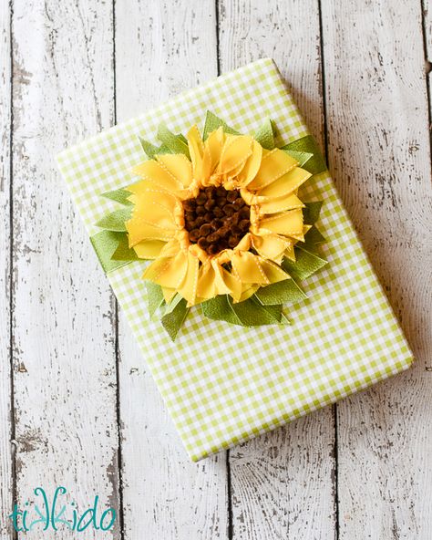 Tutorial to make a ribbon sunflower gift topper. Beautiful, creative gift wrapping idea. Gift Bow Tutorial, Ribbon Sunflower, Professional Gift Ideas, Gift Wrapping Tutorial, Gift Wrapping Techniques, Gift Wrapping Ideas, Unique Gift Wrapping, Birthday Gift Wrapping, Sunflower Gifts