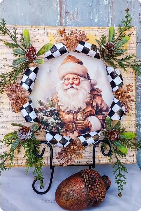 Christmas-themed picture of Santa Claus surrounded by a wreath with pinecones and black-and-white checkered ribbon. Break Out Canvas, Christmas Canvas Art Diy, Busted Canvas, Diy Christmas Canvas, Unique Art Projects, Altered Canvas, Christmas Canvas Art, Mod Podge Crafts, Christmas Crafting