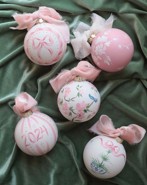 This ornament collection has so many of my favorite things...chinoiserie, florals, bows, delicate patterns, and rich textures. Plus it's PINK! Comment below to get the link sent to your DMs. They're ready to ship now! #ornaments #christmas2024 #pinkchristmas #grandmillennial #grandmillennialchristmas #babysfirstchristmas #babygirl #chinoiserie #chinoiserieartist #chinoiseriechristmas A grouping of pink and white hand-painted ornaments with velvet ribbon sits on a green velvet cloth. Pink Velvet Ornaments, Painting Ordiment Ideas, Pink Painted Ornaments, Cute Ornament Painting Ideas, Painted Ornaments Christmas Diy, Ornaments Painting Ideas, Christmas Ornaments Aesthetic, Ornament Painting Ideas, Pink Green Christmas