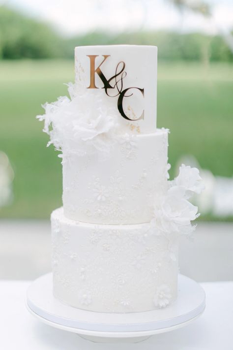 3-tiered white wedding cake Diy White Wedding Decorations, Off White Wedding Cake, 3 Tier Wedding Cake With Initials, Wedding Cake With Flowers And Pearls, White Wedding Cake With Gold Accent, Wedding Cake With Initial On Cake, 3 Tier Wedding Cake White And Gold, Wedding Cake Designs Elegant White, 3 Tier Wedding Cake Ideas Elegant