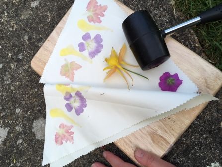 Flowers laid out on a piece of fabric with a mallet laid nearby, ready to use for Hapa Zome, Japanese flower art Hammering Flowers On Fabric, Hapa Zome, Hammer Print Flowers, Flower Hammer Art On Fabric, Summer Forest School Activities, Forest School Crafts Natural Materials, Forest School Nature Activities, Pounded Flowers, Hammered Flowers