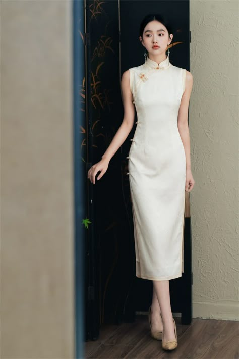 Whether you choose the pristine white for a fresh and contemporary look or the classic black for an air of timeless elegance, this Floral Jacquard Sleeveless Qipao Cheongsam Dress is ideal for formal events, cultural celebrations, or any special occasion where you want to stand out. Made from jacquard fabric featuring an intricate floral pattern. The sleeveless cut provides a modern and sleek look. Available in both white and black, allowing you to choose the perfect hue to match your personal s Chinese Qipao Traditional, Qipao Sleeveless, White Qipao, Modern Qipao Dress, Qipao Modern, Cheongsam Modern, Modern Qipao, Chinese Traditional Dress, Modern Cheongsam