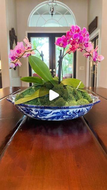 Cassie’s House • Timeless & Collected Style on Instagram: "Aren’t orchids just so pretty? Here are the steps to make this centerpiece: 1. Choose a pretty bowl. 2. Buy already potted orchids in your favorite color. Remember to consider scale - I used a small shallow bowl so I used the tiny orchids. 3. Add pebbles or sand to keep plants stable inside the bowl. 4. Add moss (any craft store will have it), don’t pack it too tight, just lightly set the moss to cover the pots - orchid roots need to breathe. 5. Remember to water it! 6. Enjoy it all winter 💕" How To Arrange Flowers In A Bowl, Orchid Bowl Centerpiece, Orchid Arrangements Centerpieces, Orchid Centerpiece Coffee Table, Orchid On Coffee Table, Multiple Orchids In One Pot, Potted Orchid Centerpiece, Orchids In Large Bowl, Orchid Bowl