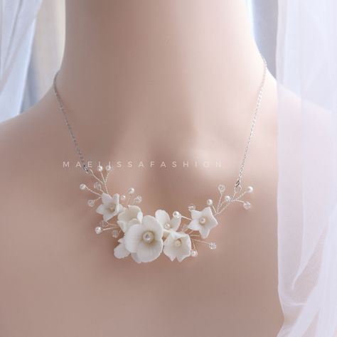 Bridal clay flower necklace of handmade porcelain blossoms creates a beautiful delicate and romantic statement and the white blossom necklace add just the right amount of sparkle in your wedding. All handmade, extrordinarily detailed and completely unique, These luxury bridal accessories are handmade in the UK. PROCESSING & SHIPPING ♥ Your order will be 1-5 business days. ♥ If you have any questions please feel free to contact me ♥ Thank you for your interest. ♥ Please check out our shop ITEM SP White Flower Necklace, Bridal Gold Necklace, Floral Necklaces, White Blossom, Beauty Logo Design, Clay Flower, Handmade Porcelain, Polymer Clay Necklace, Polymer Clay Flowers