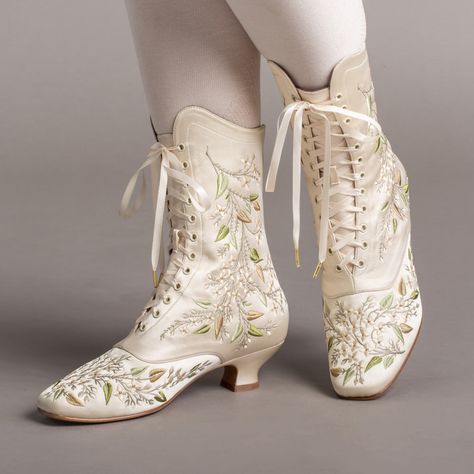 Indulge in a piece of history with Flora Embroidered Boots, an exclusive reproduction of the intricate opera and evening boots popular in the late Victorian period. Expertly crafted with intricate botanical detailing, these stunning satin boots will take you back to an era of sophistication and finesse. Wear them with bustle and Belle Epoque attire from the 1870s to c. 1900, or with modern dress as a statement piece. The Flora Boots are designed in collaboration with the Bata Shoe Museum. Every Elegant Spring Wedding Boots, Fitted Cream Boots For Wedding, Low Heel Fitted Wedding Boots, Fitted Low Heel Wedding Boots, Traditional Fitted Boots With Floral Embroidery, Satin Boots, Edwardian Shoes, Bata Shoes, American Duchess