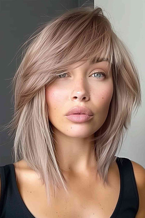 Woman with layered asymmetric bangs hairstyle. Fall Hair Color Ideas Money Piece, Assymetrical Bangs Fringes, Kaley Cuoco Hair Based On A True Story, Fall Blond Balayage, Fine Flat Hair With Bangs, This Hair Hairstyles, Inverted Bob With Layers And Bangs, Long Bob With Bangs Thick Hair, Shirt Blonde Hair Hairstyles