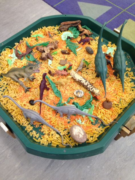 Tough tray dinosaur small world, I used pasta and lentils for texture and added natural resources e.g.  Wood, stones and green and brown shredded tissue paper. Dinosaur Tough Tray Ideas, Pasta Tuff Tray Ideas, Dinosaur Tuff Tray Ideas, Dinosaur Tuff Tray, Dinosaurs Eyfs, Dinosaur Small World, Tuff Tray Ideas Toddlers, Dinosaur Theme Preschool, Dinosaur Activities Preschool