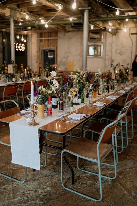 Wildflower wedding theme with a botanical wedding tablescape decorated in colourful wildflower arrangements Industrial Floral Wedding, Botanical Theme Wedding, Colourful Winter Wedding, Wildflower Tablescape, Brewery Wedding Decorations, Industrial Wedding Table, Marchesa Bridal Gowns, Folksy Wedding, Industrial Wedding Style