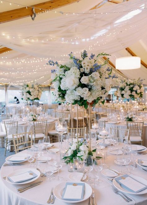 A beautiful tall arrangement made up of roses, hydrangea, delphinium and greens surrouded by candlelight and soft twinkling lights above. Hydrangea Aisle Wedding, Wedding Hydrangea Centerpiece, Elegant Classy Wedding Decor, Light Blue Gold Wedding, Light Blue And Gold Wedding, Wedding Table Lighting, Castle Hill Inn Wedding, Soft Blue Wedding, Wedding Ballroom