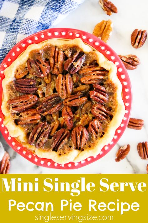 Pecan pie in a red pie plate sitting on a white marble table with scattered pecans on the table and a blue dish cloth in the background. Single Serve Pecan Pie, 4 Inch Pie Recipes, Pecan Pie For Two, Pie Tarts Mini, Pi Day Recipes, Pie With Shortbread Crust, Pie Day Recipes, Individual Pecan Pies, Food For One Person