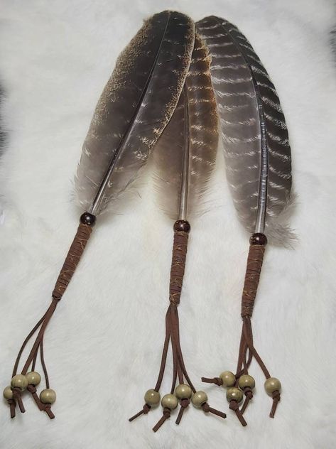 "Representing \"Wind\" in the four elements, Smudge Feather, for Ceremonial and Ritual Purification and Cleanse. Made with loving intention and careful detail. Each hand crafted piece is unique and made from Natural Barred Round Turkey Feathers that range from 8 to 10 inches in length. Perfect for Traditional Smuding to waft the smoke. Use with Cedar, Sweetgrass, White Sage, or Palo Santo Holy Wood. ❤ Fan Features:  Smudge Feather, about 12 inches long including about 3 to 4 inches of fringe, in Smudge Feathers Diy, Hanging Feather Decor, Diy Feather Decor, Feather Smudge Fan, Smudging Feathers, Feather Diy, The Four Elements, Native American Crafts, Feather Fan