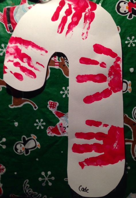 Candy cane handprint Handprint Candy Cane, Stocking Art For Toddlers, Santa Handprint Crafts For Kids, Candy Cane Toddler Craft, Santa Art For Toddlers, Candy Cane Ornament Craft, Gingerbread Toddler Art, December Art For Infants, Candy Cane Art For Toddlers