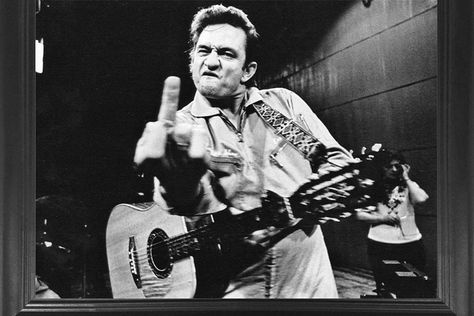 Amazon Besides the picture of him standing outside Folsom Prison, this is the most iconic photo of Johnny Cash. Collector's Weekly says that during a performance at San Quentin Prison, music photographer Jim Marshall asked Johnny Cash to take a picture for the warden. Johnny decided flipping the bird spoke much louder than words. It was […] The post The Story Behind the Famous Photo of Johnny Cash at San Quentin Prison appeared first on Wide Open Country. Johnny Cash Middle Finger, Finger Photo, Anger Problems, Jim Marshall, Bert Stern, Famous Portraits, San Quentin, John Malkovich, Diane Arbus