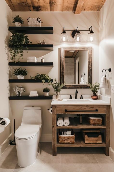 A modern bathroom featuring white subway tile walls, black fixtures, and a rustic wood vanity with open shelving. The vanity is topped with a white countertop and a rectangular mirror with a wooden frame. Three black pendant lights hang above the mirror. To the left of the vanity, there are black floating shelves adorned with various green plants. Above the toilet, there are more floating shelves with bathroom decor and plants. The bathroom includes a white toilet and light gray floor tiles. Ensuite Decor Ideas, Black And Wood Interior Design Modern, Wood White And Black Bathroom, Green Decor Bathroom Ideas, Natural Wood And Black Bathroom, Black White And Natural Wood Bathroom, Restroom Inspo Aesthetic, Above Toilet Shelving, Greenery In Bathroom