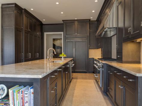 Storage is no issue in this luxurious kitchen. A large kitchen island provides plenty of counter space for prepping and also features a shelving unit to hold cookbooks. To the left, a floor to ceiling pantry is a cook's dream. Multipurpose Kitchen Island, Wood Kitchens, Multipurpose Kitchen, Cheap Countertops, Ikea Kitchen Cabinets, Huge Kitchen, Craftsman Kitchen, Kitchen Countertop Materials, Large Kitchen Island