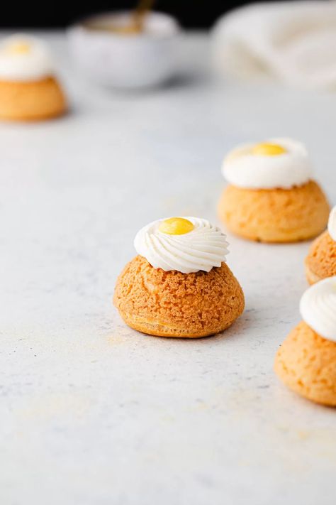 These Paris style lemon cream puffs will have everyone wanting more! These lemon puffs are made with craquelin, pate a choux, lemon curd, and stabilized whipped cream. You can make them with or without the extra whipped cream and curd on top. Either way, these are impressive cream puffs! I often take my inspiration from Paris patisseries where you can buy choux pastries, craquelin, and cream puffs. Lemon Cream Puffs, Cream Puff Dough, Stabilized Whipped Cream, Choux Pastry, Cream Puff, Paris Style, Lemon Cream, Sweet Food, Cream Puffs