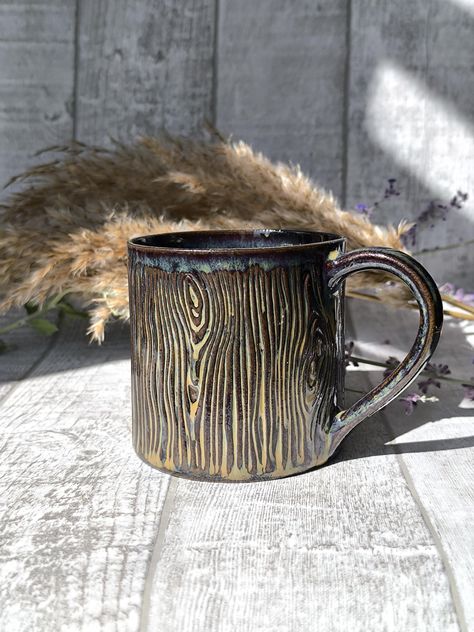 Handmade ceramic mug with Wood log pattern.  These mugs are handbuilt (without an electric potters wheel) which makes every piece exceptionally unique. The mug has a pattern that replicates tree bark. The mug is glazed in dark brown glaze, which makes it resemble a wood log . The bottom of the mug is left unglzed where you can see the original color of the clay. The mug has a handle which sits comfortably in your hand. The pattern also creates a massage like feeling in your palm when you hold th Ceramic Mugs Handmade, Rustic Pottery Mugs, Nature Inspired Ceramic Mugs, Mountain Mug Pottery, Handmade Ceramic Mugs, Ceramic Mugs Mountain, Ceramic Mugs Mountain Carved, Cosy Autumn, Pottery Inspo