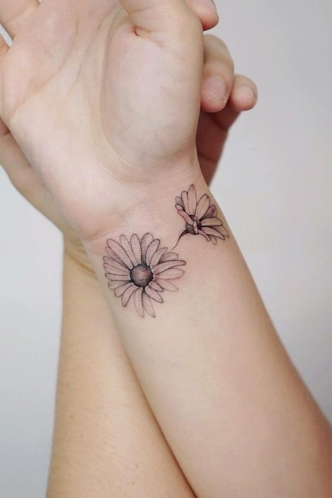 33 Fabulous Daisy Tattoo Ideas and Designs (2022) Daisy Wrist Wrap Tattoo, Line Work Daisy Tattoo, Daisy Wrist Tattoos For Women, Daisy Wrist Tattoo, White Daisy Tattoo, Daisy Tattoo Ideas, Daisy Tattoo Meaning, Daisy Chain Tattoo, Daisy Tattoos