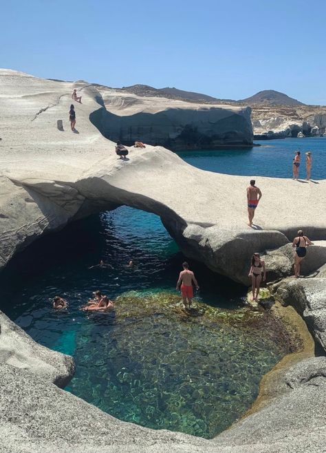 The coast of milos where the sea creates a natural pool. People bathing in swim wear