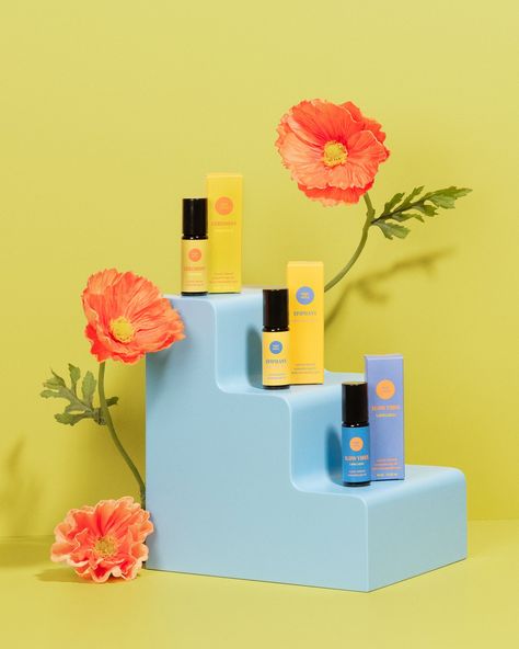 3 aromatherapy oils on a blue prop shaped like a set of stairs - with three levels. There are orange poppies around the stairs and the backdrop is a chartreuse color. The aromatherapy oils are from Thought Sanctuary. Bright Colorful Product Photography, Product Photography Trends 2023, Props Product Photography, Color Block Product Photography, Conceptual Product Photography, Product Photography Colorful, Colourful Product Photography, Bright Product Photography, Flower Product Photography