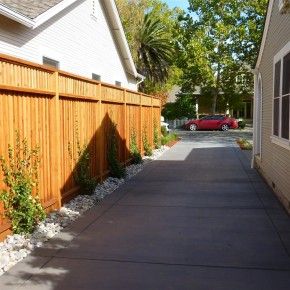 Front Yard Concrete Driveway and Redwood Fence - Here they've piled up about a foot I'd guess of gravel between the two yards. Nice fence too. Landscape Between Driveways, Redwood Fence, Driveway Fence, Yard Privacy, Diy Backyard Fence, Front Yards Curb Appeal, Walkway Landscaping, Backyard Garden Layout, Yard Fence