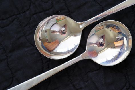 reflections on household objects, silver spoons:  Several shots taken on black quilted placemat background, silver soupspoons from silver drawer.  One example.  Others taken outdoors on bubble wrap, some with stainless steel forks and knives, etc.  Some of reflecting and refracting glassware objects, scenes through glassware, empty or containing water or beverages. Reflective Objects, Reflection And Refraction, Yin Yang Art, Reflection Art, Reflection Photography, Shiny Objects, Black Quilt, Silver Spoons, Ambient Lighting