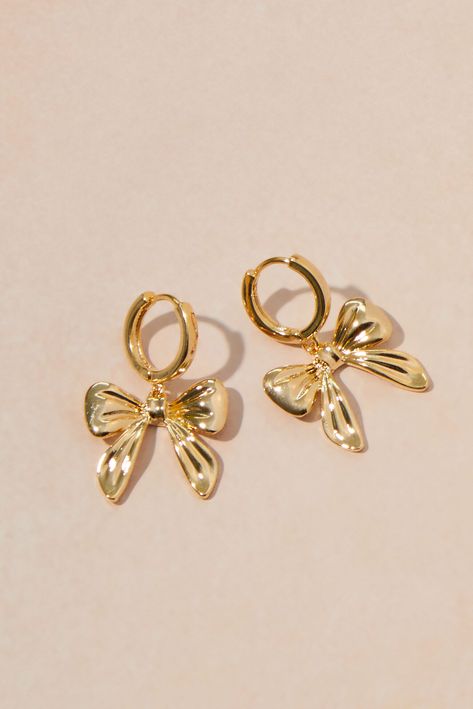 Add a touch of playful charm to your look with these earrings, a delightful combination of modern minimalism and timeless femininity. These petite hoops transition seamlessly from casual daytime wear to dressier evening occasions.   Closure: Saddle back Material: 18K Gold dipped IMPORTED Cute Gold Dangle Earrings, Women Jewelry Gold, Gold Christmas Earrings, Bow Hoop Earring, Women’s Earrings, Stacked Jewelry Earrings, Womens Gold Jewelry, Gold Jewelry Piercing, Cute Stuff For Christmas List