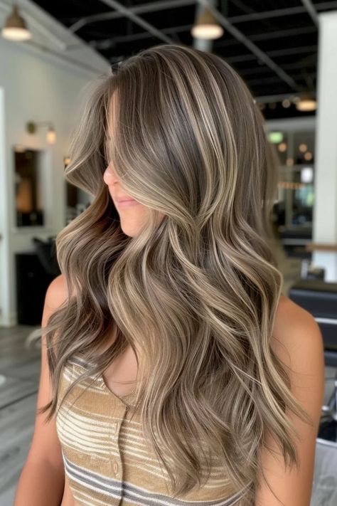 Woman with long, wavy hair featuring blonde highlights in a salon setting. Cool Brown Blonde Hair, Highlights With Dirty Blonde Hair, Dirty Blonde With Blonde Highlights, Caramel Highlights On Dirty Blonde Hair, Dark Blonde Hair Highlights, Blonde With Brown Lowlights Caramel, Dark With Blonde Highlights, Sandy Blonde Balayage Brown Hair, Low Light And Highlights