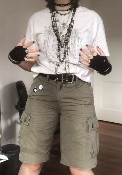 A mid-sized person/girl wearing a    white grephic t-shirt, green tights, black fingerless gloves, green cargo shorts, leg warmers, platform dr. Martens and multiple dark green and gray crystal rings and bracelets. 		The person is also wearing multiple silver necklaces. Outfit Inspo Gender Neutral, Summer Outfit Nonbinary, Cool Masculine Outfits, Soft Alternative Outfits Male, Skirt Masc Outfit, Masc Goblincore Outfits Summer, Fairy Grunge Aesthetic Outfit Male, Masc Fits Aesthetic, Fairycore Outfit Masc