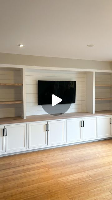 Suits & Sawdust | Custom Woodworking on Instagram: "Living Room Goals 🔥   This built-in entertainment wall made such good use of our client's living room space! It frames their TV beautifully while adding so much additional storage in the wall-to-wall lower cabinets. The white paint brightens the room while adding stained elements like the solid 15 ft countertop and upper shelves in a natural tone, warms the space up providing an extra homey feel 🤩  If you've debated booking a built-in, this is your sign! DM us ❤️ . . . . . . . . . . .  #shiplapwall #shiplapwalls #shiplapfireplace #livingroomstyle #livingroomgoals #livingroommakeover #accentwall #fyp #pov #livingroomideas #beforeandafter #feature wall #hometransformation #goals #storage #storagesolutions #customcabinetry #customwoodworki Long Wall Of Lower Cabinets, Built In Shelves Living Room Long Wall, Tv Built In Without Fireplace, Built In Decor Ideas, Built In Cabinets With Bookshelves, Tv Room Cabinets Built Ins, Build In Shelf Living Room, Full Wall Tv Unit With Storage, Wall To Wall Cabinets Living Room