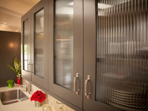 The glass doors on these gray kitchen cabinets lend a modern feel to this kitchen. The wavy glass helps obscure the contents inside, ensuring that the chic cabinets remain functional. Kitchen Cabinets Glass Inserts, Replacing Kitchen Cabinets, Kitchen Cabinet Glass, Glass Kitchen Cabinet, Types Of Kitchen Cabinets, Glass Kitchen Cabinet Doors, Glass Kitchen Cabinets, Cabinet Glass Doors, Cabinets With Glass Doors