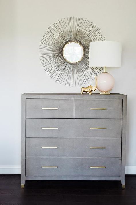 A black sunburst mirror is mounted over a gray dresser accented with brass pulls lit by a pink glass globe Gray Dresser, French Headboard, Nailhead Headboard, Space Themed Room, Grey Dresser, Dresser Design, Boy Bedroom Design, Transitional Bedroom, Furniture Design Living Room