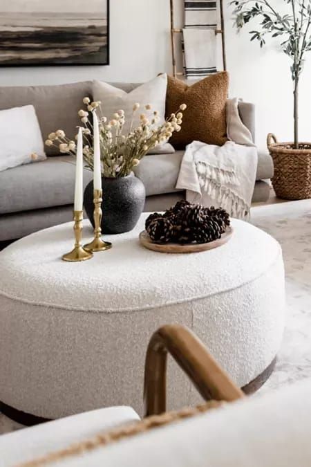 Round Ottoman Decor, Couch And Ottoman Ideas, Attic Living Rooms, Ottoman Coffee Table Decor, Modern Home Inspiration, Round Ottoman Coffee Table, White Ottoman, Apartment Decorating Living, Living Room Pouf