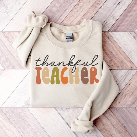 Thankful Teacher Sweatshirt, Thanksgiving Teacher Shirts for Men & Women, Thanksgiving Gift for Teacher, Autumn Teacher Tees, Fall Vibes Tee ---------- Ordering Your Custom Design T-shirt: Step by Step ---------- 1. Select your preferred t-shirt color. 2. Specify your desired size. 3. Pick the color for both your design and text. 4. Ensure that each step of your order is accurately completed. M A T E R I A L S → Our solid color options such as White and Black consist of 100% Cotton. → The Heathered Colors are a blend of cotton and polyester, ensuring a luxuriously soft feel. → Crafted as Short Sleeve Crew-Neck Unisex T-Shirts. → Composed of soft, high-quality Sueded Jersey fabric. → Taped shoulder-to-shoulder for enhanced durability. → Side Seamed for a refined finish. → Boasts a Retail fi Fall Teacher Shirt, Thanksgiving Teacher Shirts, Fall Teacher Shirts, Teachers Thanksgiving, Teacher Sweatshirt, Teacher Tees, Thanksgiving Gift, Gift For Teacher, Thanksgiving Gifts