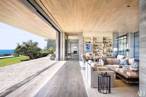 A painting by the Bruce High Quality Foundation is set into bookshelves in the living room; both the bookshelves and the cocktail table in the foreground are by Scott Mitchell, who collaborated with Denise Kuriger on the armchairs and sofa, the latter covered in a de Le Cuona fabric Malibu Mansion, Malibu Home, Open Plan Living Room, Indoor Outdoor Living, A Living Room, Open Plan Living, Architectural Digest, Living Design, Open Plan