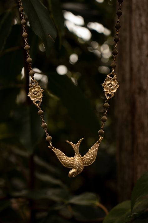 "A beautiful bird and flower necklace hand crafted from solid (not plated) raw brass featuring a diving swallow suspended from a heavier solid (not plated) raw brass chain that can be made in any length you desire. This necklace feels so good on! The chain had a nice weight to it, and the brass bird and flowers are a thicker heavier gauge.  Swallows symbolize happiness and positive change. Paired with spring flowers, this necklace is a great piece to wear for new hopeful beginnings and finding y Ceramic Jewerly, Swallow Necklace, Vintage Trinkets, Medieval Necklace, Spring Necklace, Brass Bird, Bird And Flower, Pagan Jewelry, Beautiful Bird