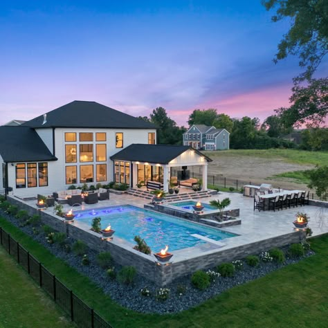 A pool with the works! This gunite swimming pool is surrounded by a spacious travertine patio. The pool includes color changing lighting, a sun ledge, bench seating and laminars. See more: <https://www.pool-fx.com/recent-projects/outdoor-living-at-its-best-westerville-oh> #swimmingpool #gunitepool #outdoorliving Pool With Covered Deck, Backyard With Pool And Hot Tub, Underground Pool Ideas, Big Backyard With Pool Ideas, Patio Pools, Backyard Decor With Pool, Outdoor Living Pool Area, Backyard Pool With Hot Tub, Inground Pool With Deck