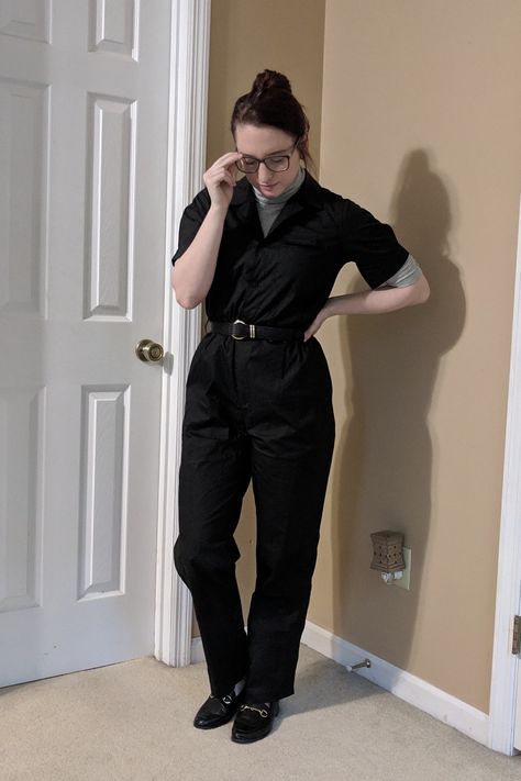 Black boiler suit layered with a ribbed gray turtleneck and accented by a black leather belt and black leather loafers, both featuring gold hardware. Black Boiler Suit, Suit Turtleneck, Gray Turtleneck, Grey Turtleneck, Boiler Suit, Black Leather Loafers, Black Leather Belt, Leather Loafers, Leather Belt