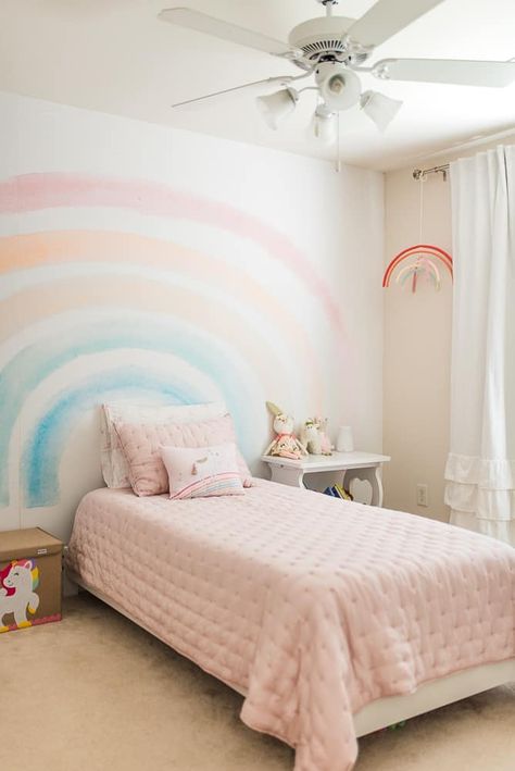 Beautiful bedroom for a little girl! Lots of pink, rainbows, and unicorns to turn her bedroom into a princess dream. With the rainbow mural accent wall (simple wallpaper rainbow!) and the feminine pink bedding from Pottery Barn Kids, this little girls bedroom will be her favorite place to sleep. Girls Rainbow Bedroom, Girls Dream Bedroom, Girls Bedroom Themes, Rainbow Mural, Rainbow Bedroom, Girls Bedroom Makeover, Unicorn Bedroom, Pink Bedroom For Girls, Big Girl Bedrooms