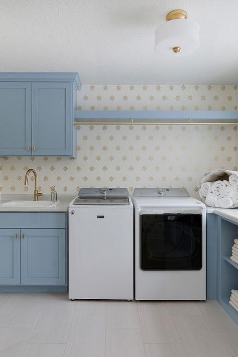 Lovely blue laundry room features a white washer and dryer placed beneath a blue shelf fitted with a brass clothes drying rod. Rod Above Washer And Dryer, White Apron Sink, Laundry Room Cabinet Ideas, Room Cabinet Ideas, Laundry Room Cabinet, Transitional Laundry Room, Traditional Laundry Room, Grey Laundry Rooms, Blue Kitchen Island