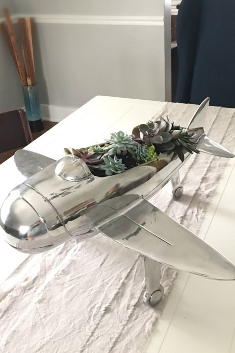 Getting creative with pieces we love from @HomeGoods. Airplane bottle holder turned succulent garden centerpiece. #homegoods #centerpiece #alternativeuse #airplane #aviation #pilot #travel #succulents Aviation Inspired Decor, Aviation Centerpiece Ideas, Aviation Home Office, Airplane Living Room Decor, Aviation Themed Home Office, Travel Theme Living Room, Aviation Themed Bedroom, Pilot Office, Office Decor Travel Theme