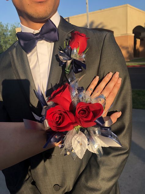 Corsage navy blue and red roses Corsage Prom Navy Blue Dress, Red White And Blue Corsage, Corsage Prom Red Dress, Red And Blue Corsage, Corsage Navy Blue, Navy Blue And Silver Corsage, Red Black And White Corsage Prom, Dark Blue Prom Dress, Red Corsages