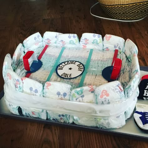 Ice rink diaper cake! Perfect for the hockey lover you know! ❤️💙 Gender Reveal Ideas Hockey Theme, Hockey Puck Gender Reveal, Hockey Gender Reveal Party, Hockey Themed Gender Reveal, Hockey Themed Nursery, Hockey Gender Reveal Ideas, Hockey Themed Baby Shower Ideas, Hockey Baby Shower Ideas, Gender Reveal Hockey