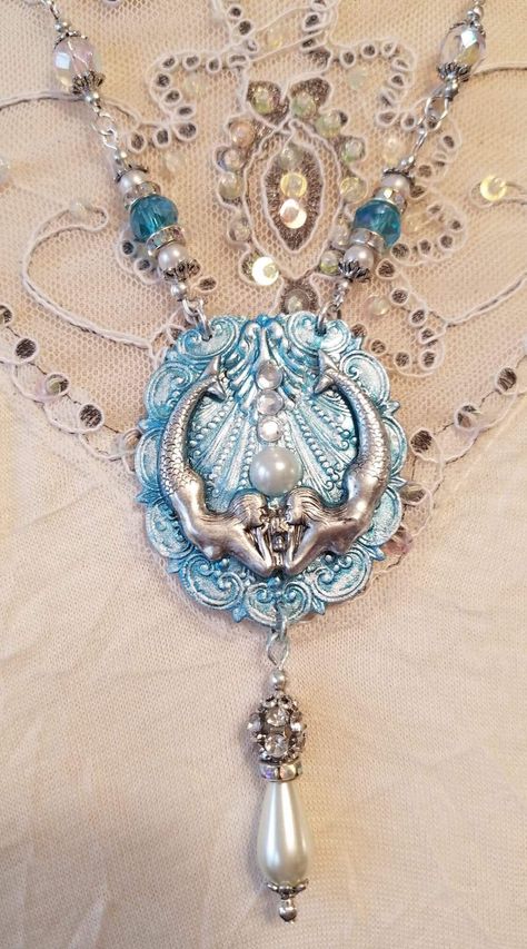 The Mermaid Necklace is designed and handcrafted by Viviana Jewelry Designs.  The twin mermaids and sea shell pendant is made from the finest silver ox stamping.  The mermaids are resting upon silver ox vintage shell stamping that has been hand painted turquoise, then embellished with faux pearls and crystals.   The necklace is beaded with beautiful glass pearls, turquoise color glass beads and Chrystal spacer beads.    I love mermaids and these twin mermaids look like they are swimming under the sea.  If you love mermaids like me, then this necklace is for you. It is a one of a kind design, there are no other mermaid bracelets like it.   **When ordering, please specify what length you want the necklace to be.   Thank you so much for shopping Viviana Jewelry Designs.  Have a wonderful bles Twin Mermaids, Mermaid Accessories, Jewellery Shop Design, Mermaid Bracelet, Mermaid Jewelry, Mermaid Necklace, Funky Jewelry, Jewelry Lookbook, Shell Jewelry